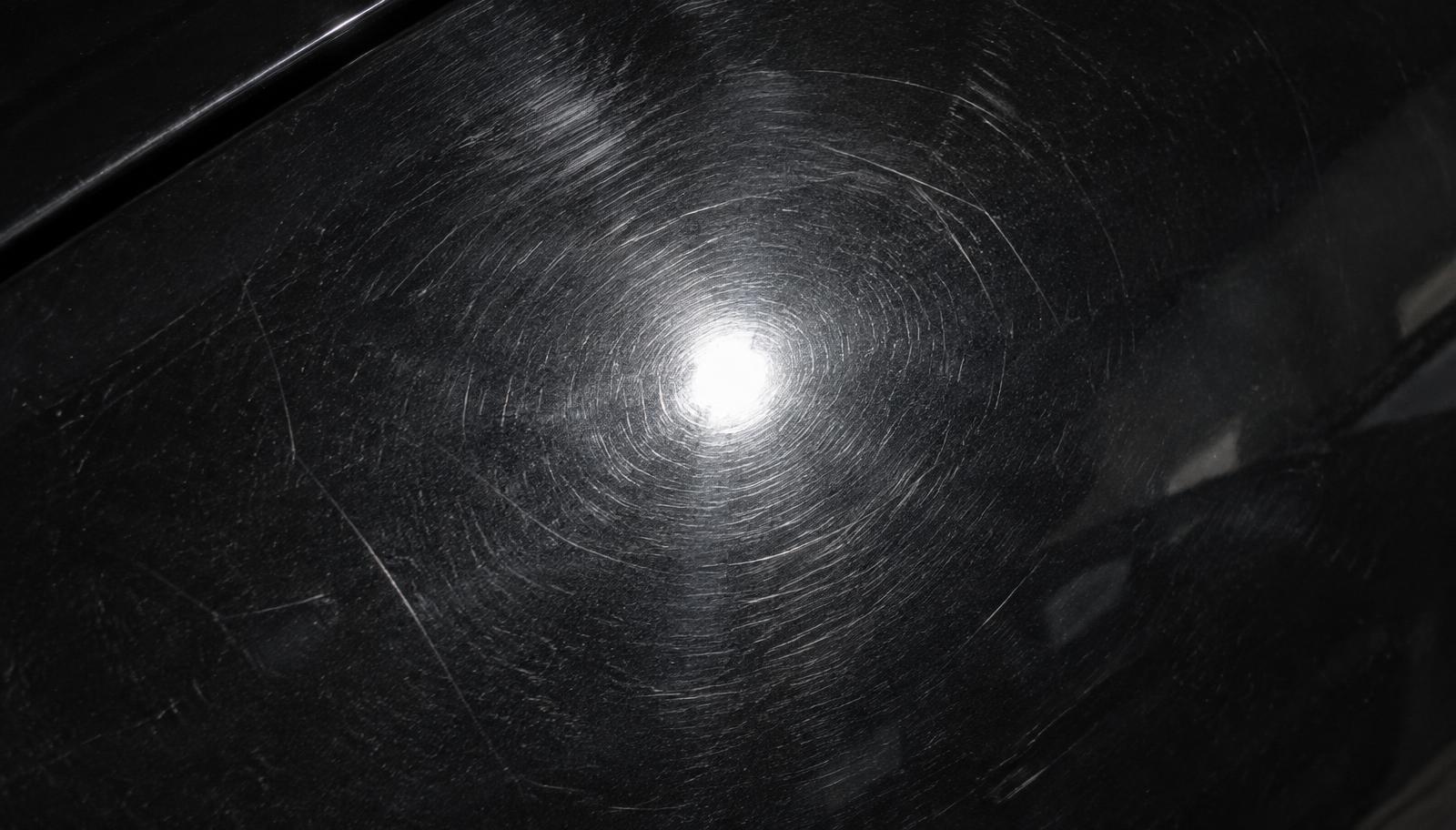 Swirl marks and fine scratches on a dark car panel before paint correction in Bolingbrook, IL